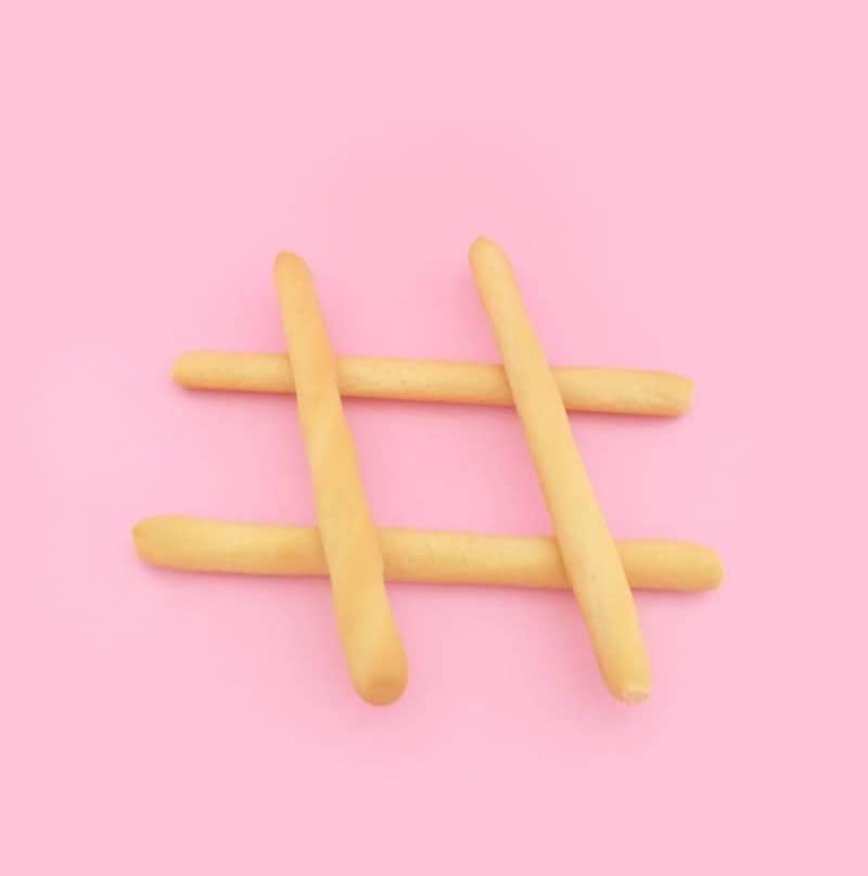 four brown wooden sticks on pink surface