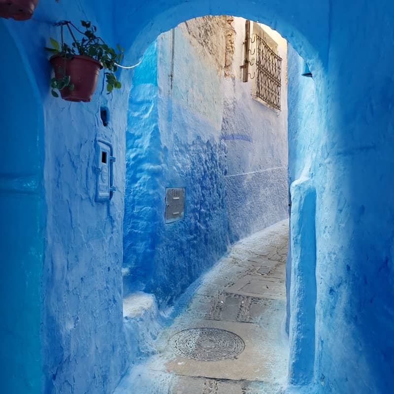 A blue alleyway with an arched entrance.