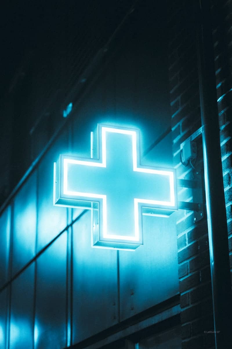 A glowing blue cross signifies a pharmacy.