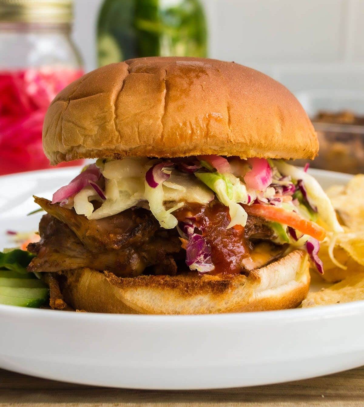 pulled pork sandwich on white plate.