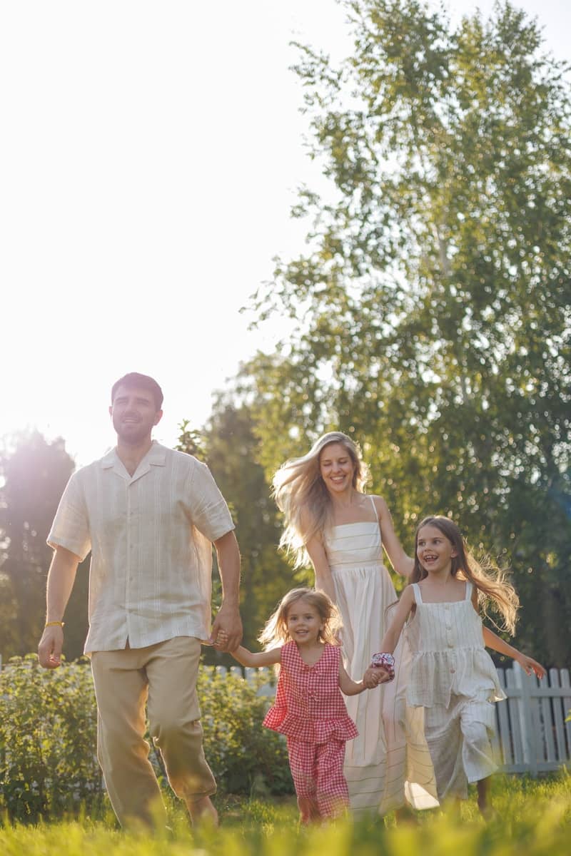 A happy family running together in a sunlit garden.