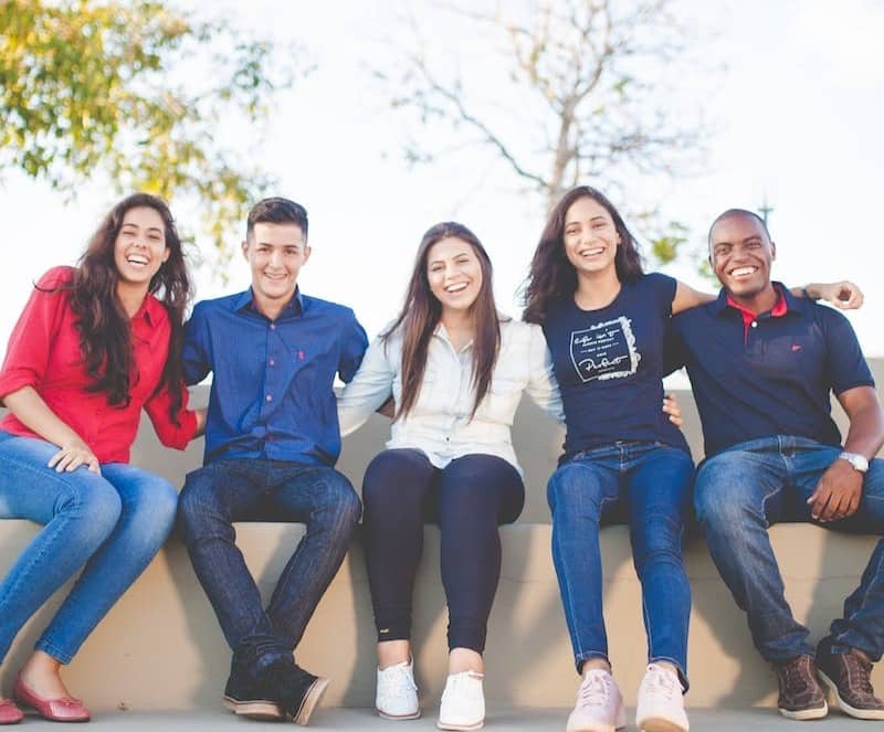 group of people sitting on bench near trees duting daytime