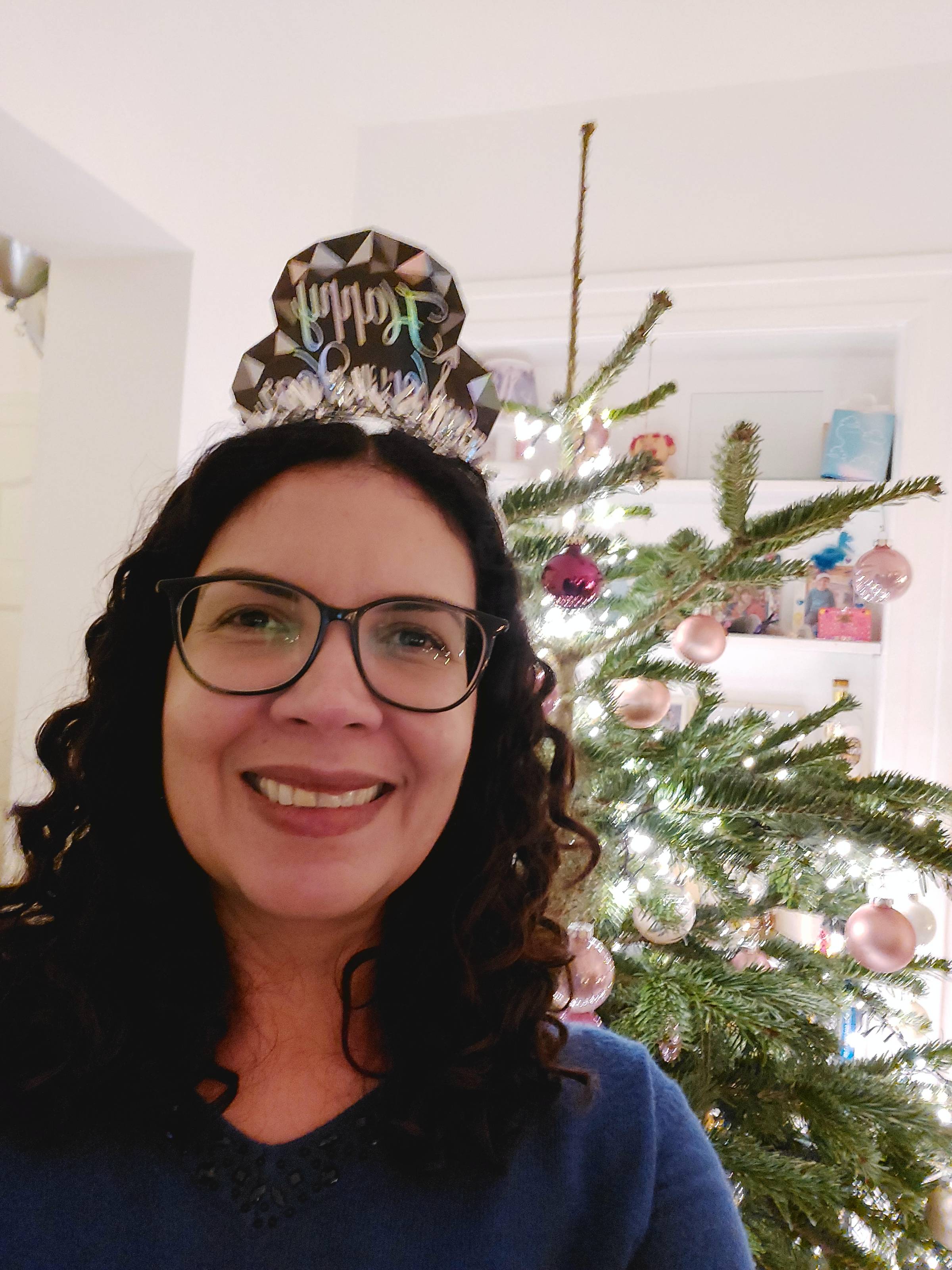 Delise Torres posing in front of a Christmas tree on New Year's Eve
