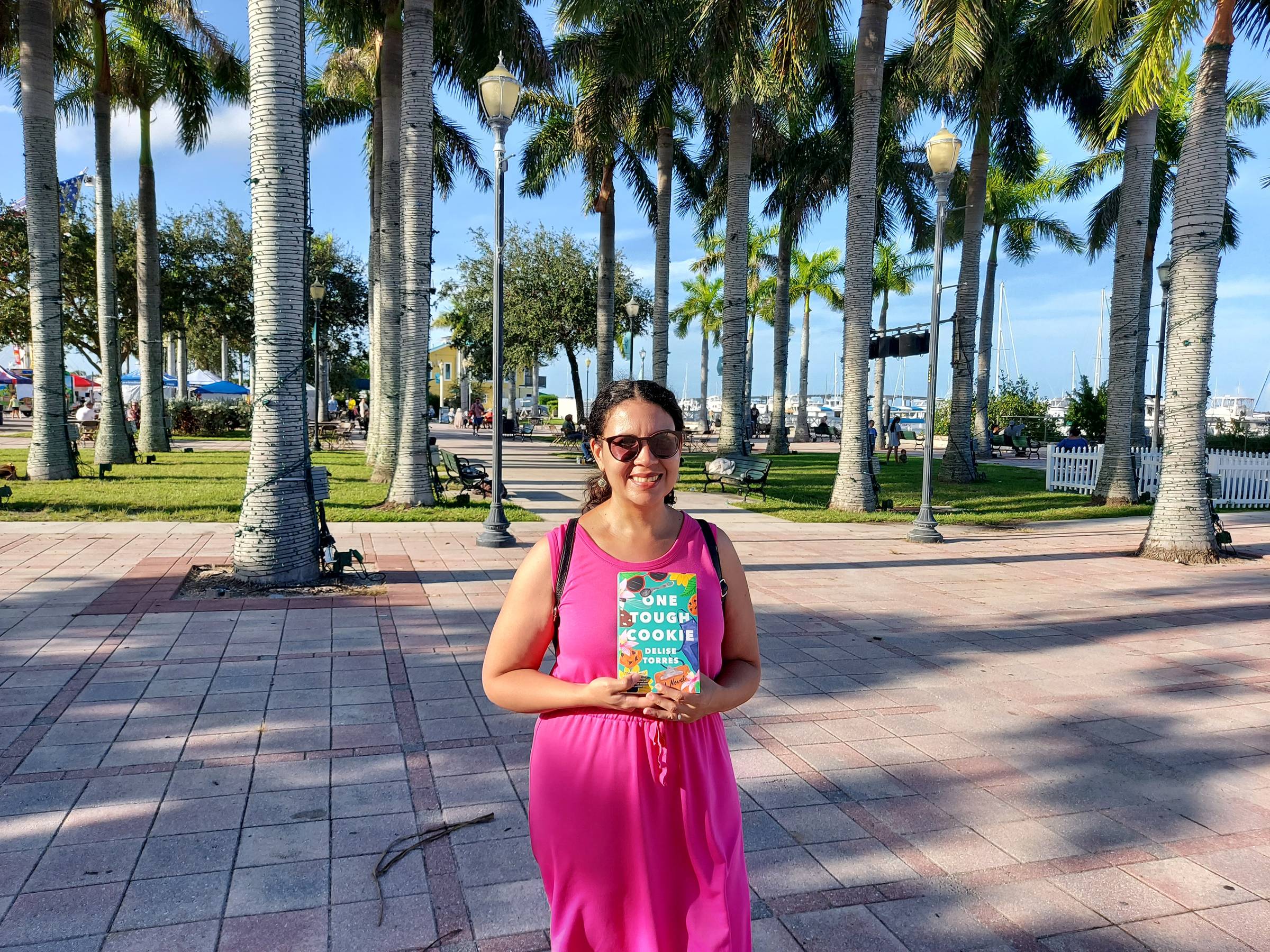 Delise Torres posing with a paperback copy of One Tough Cookie at Marina Square in Fort Pierce, Florida