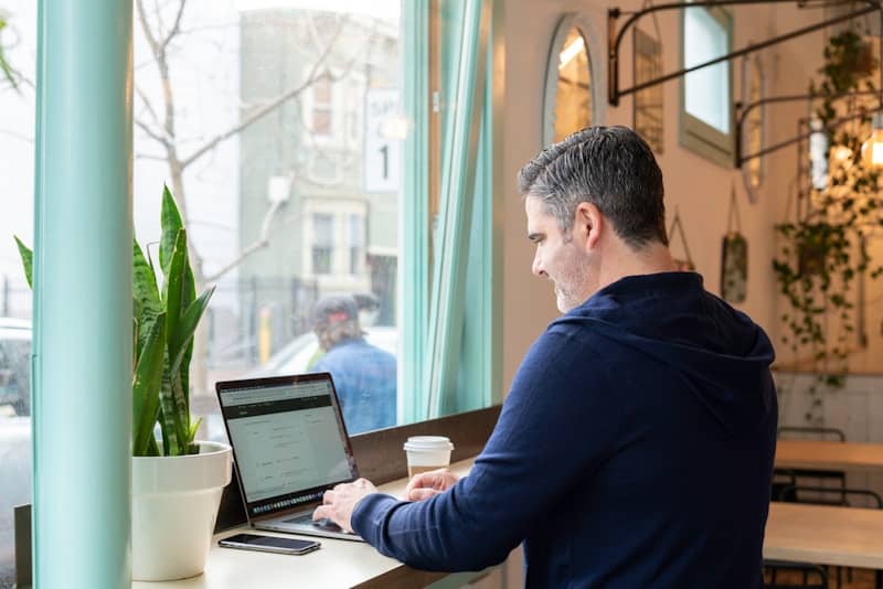 man in blue long sleeve shirt using macbook pro