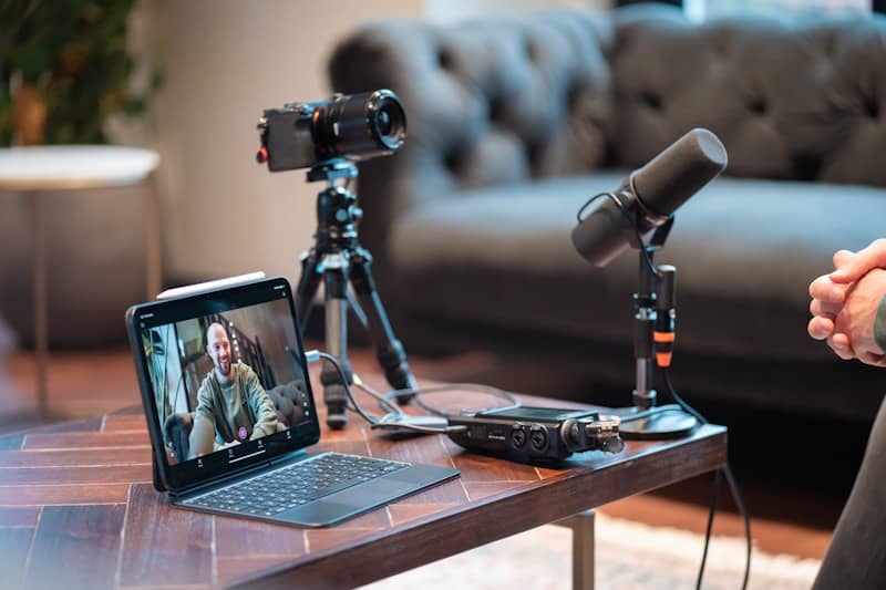 Podcast recording setup with camera, microphone, and tablet.