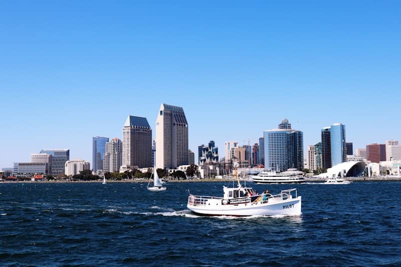 Boats cruise in front of a city skyline.