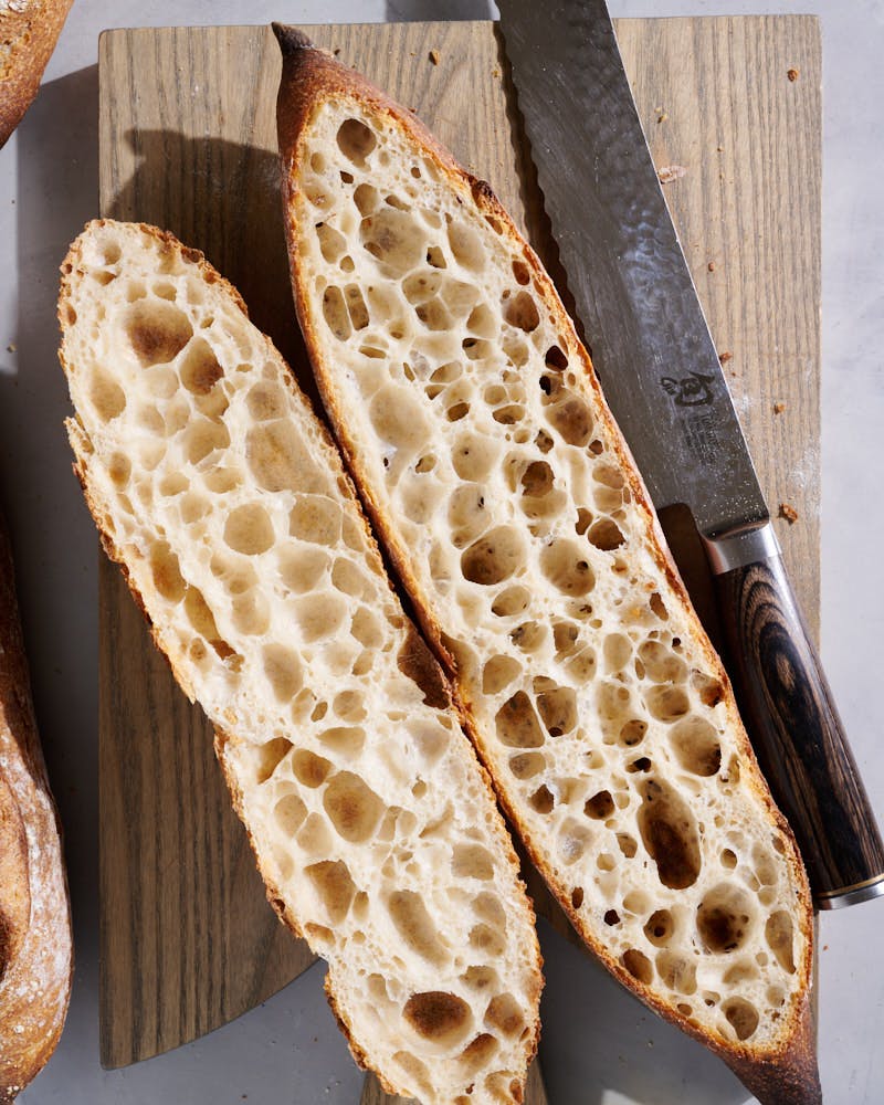 Thin-crusted sourdough baguettes cut open.