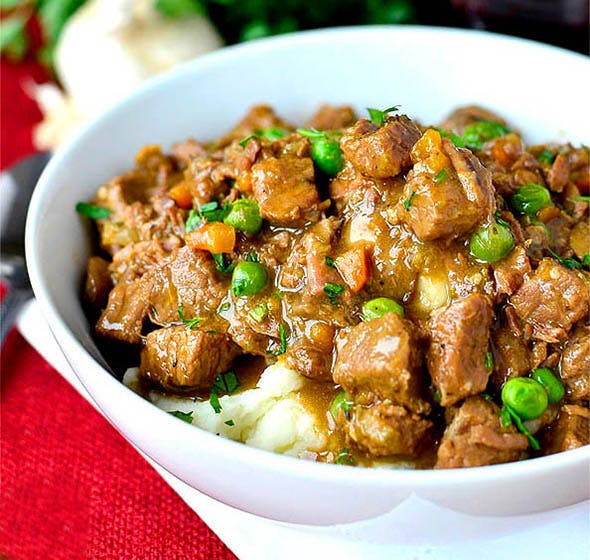 bowl of beef stew and mashed potatoes