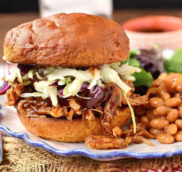 BBQ pork sandwich on plate with baked beans