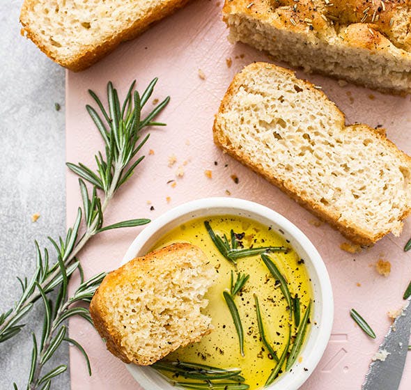 sliced of gluten free focaccia bread with dish of olive oil