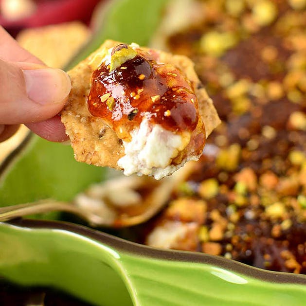 cracker dipping into fig and pig dip