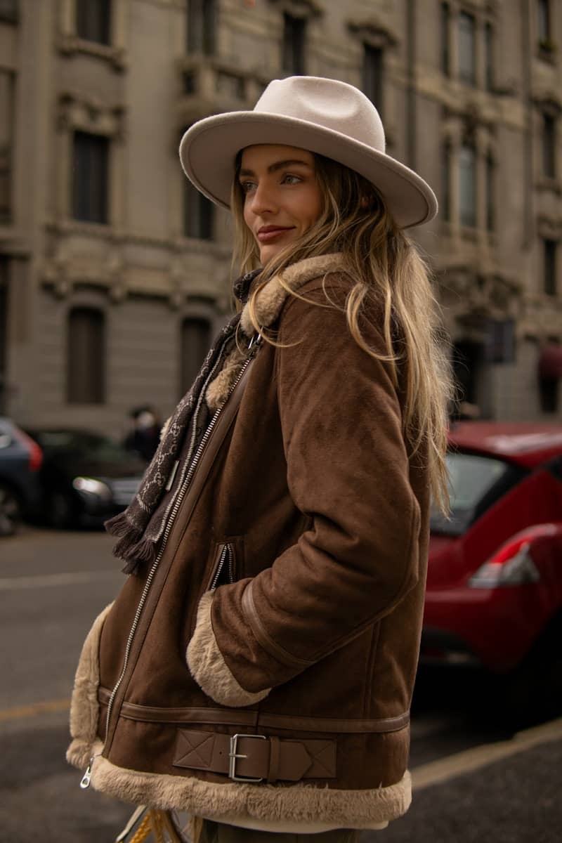 A woman in a hat is standing on the street