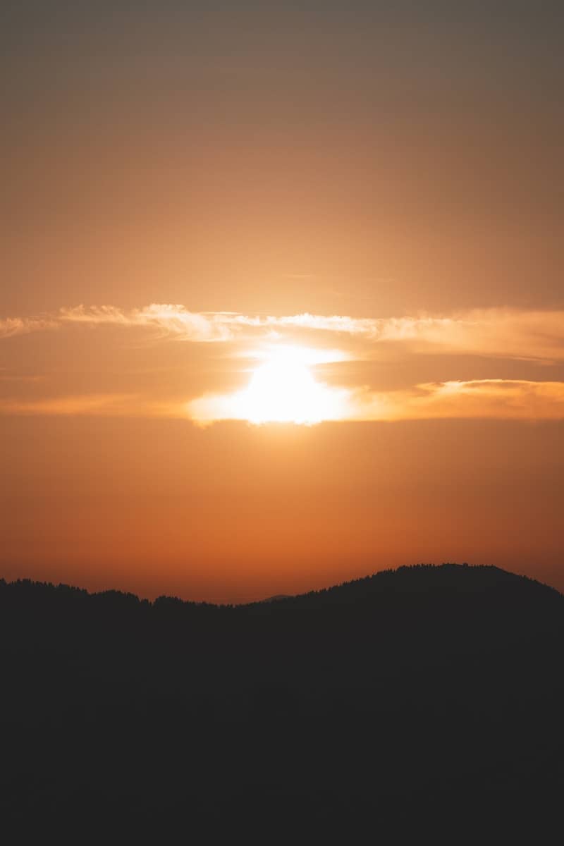 The sun is setting over a mountain range