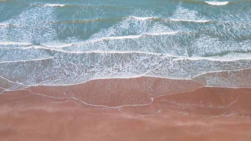 Aerial view of ocean waves on a sandy beach