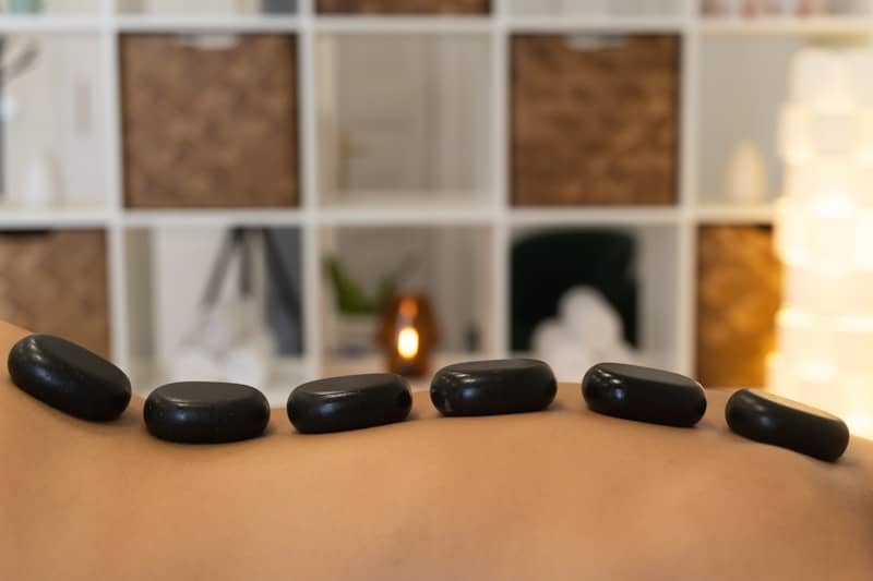 Hot stones rest on a person's back.