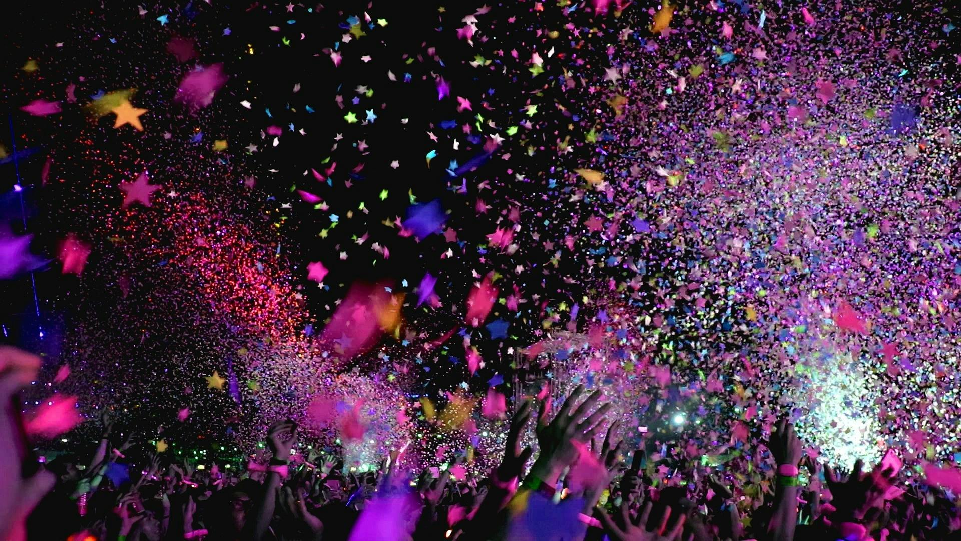 A confetti cannon over a crowd of people in a dark room