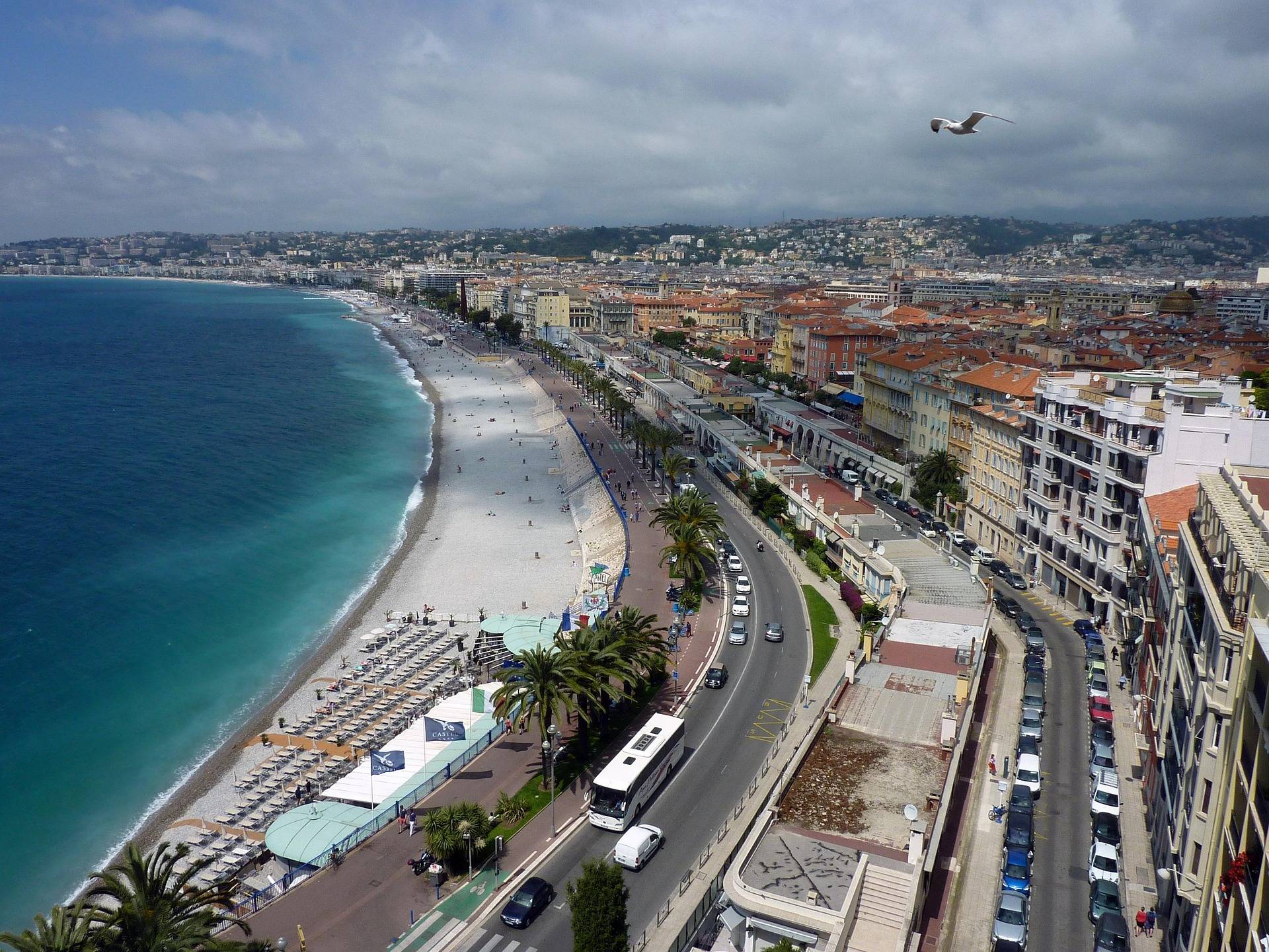 A seagull flies over the Bay of Nice on a cloudy day