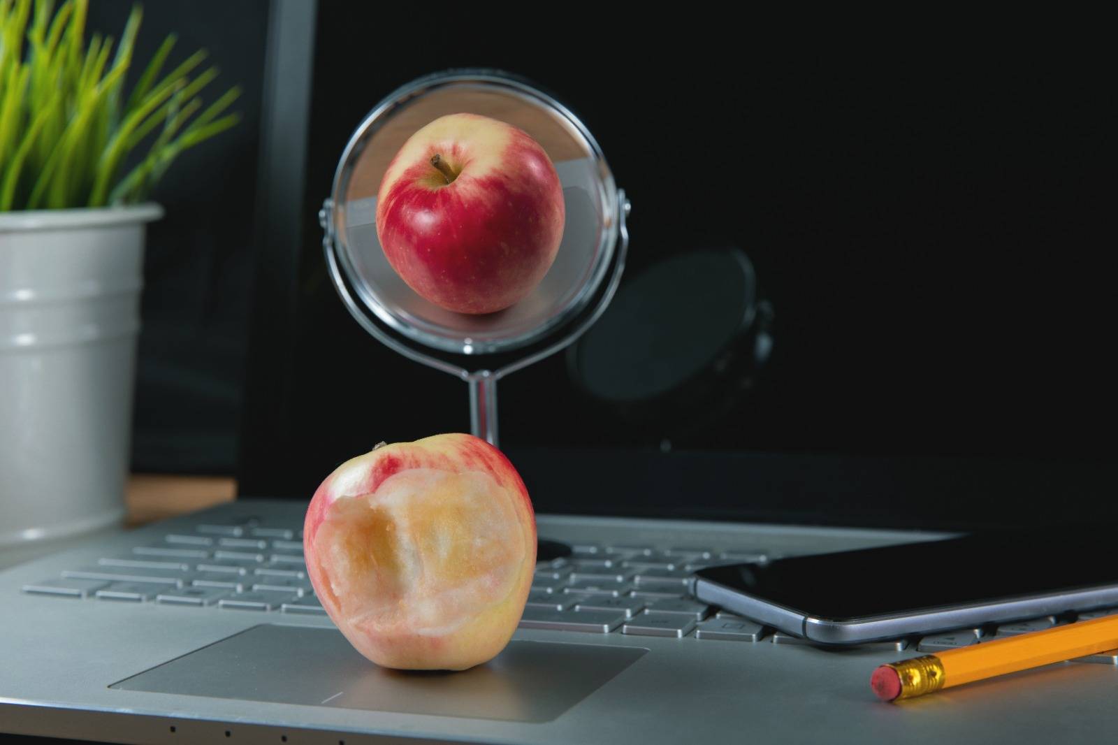 An image of a bitten apple reflected in a mirror showing the side that wasn't eaten by Ronstik on Adobe Stock.