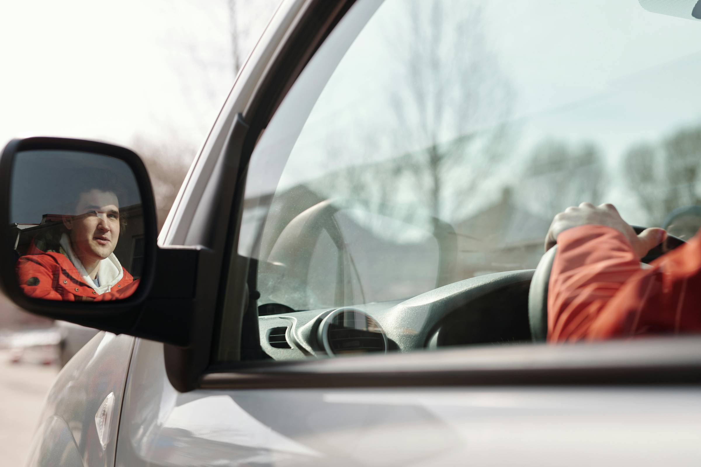 A woman driving and looking at her side mirror in fear