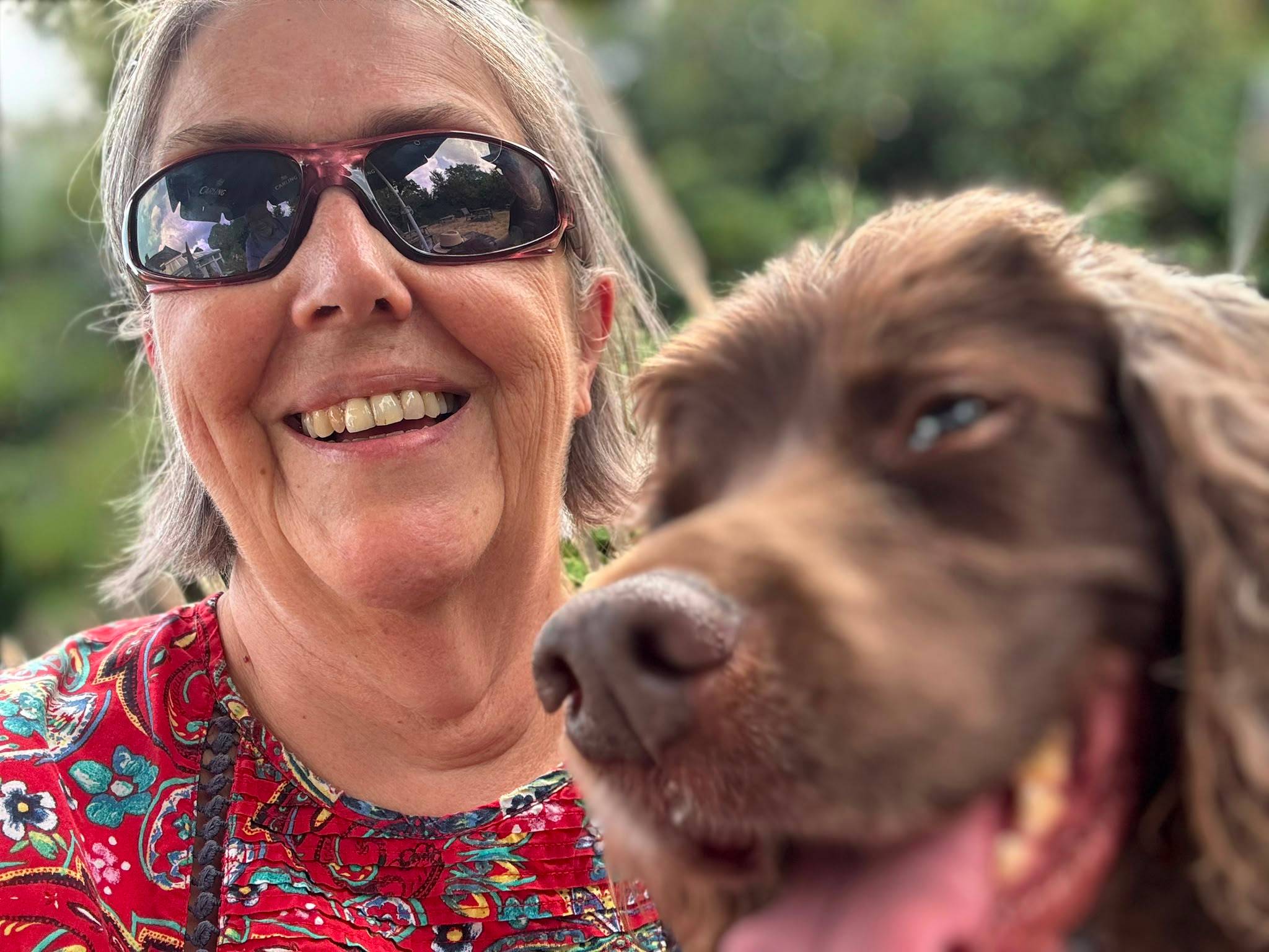 Claire is taking a selfie with Poppy the brown Cocker Spaniel.