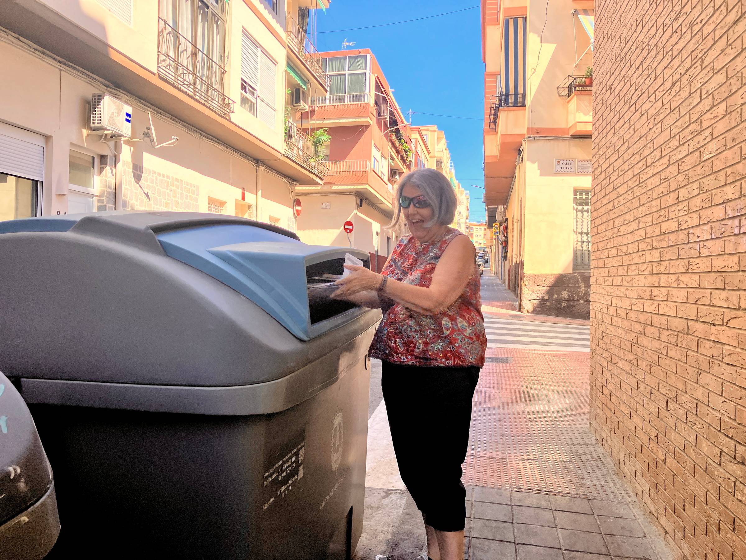 Claire stands on a street in Spain and tosses the first drafts in the recycle bin.