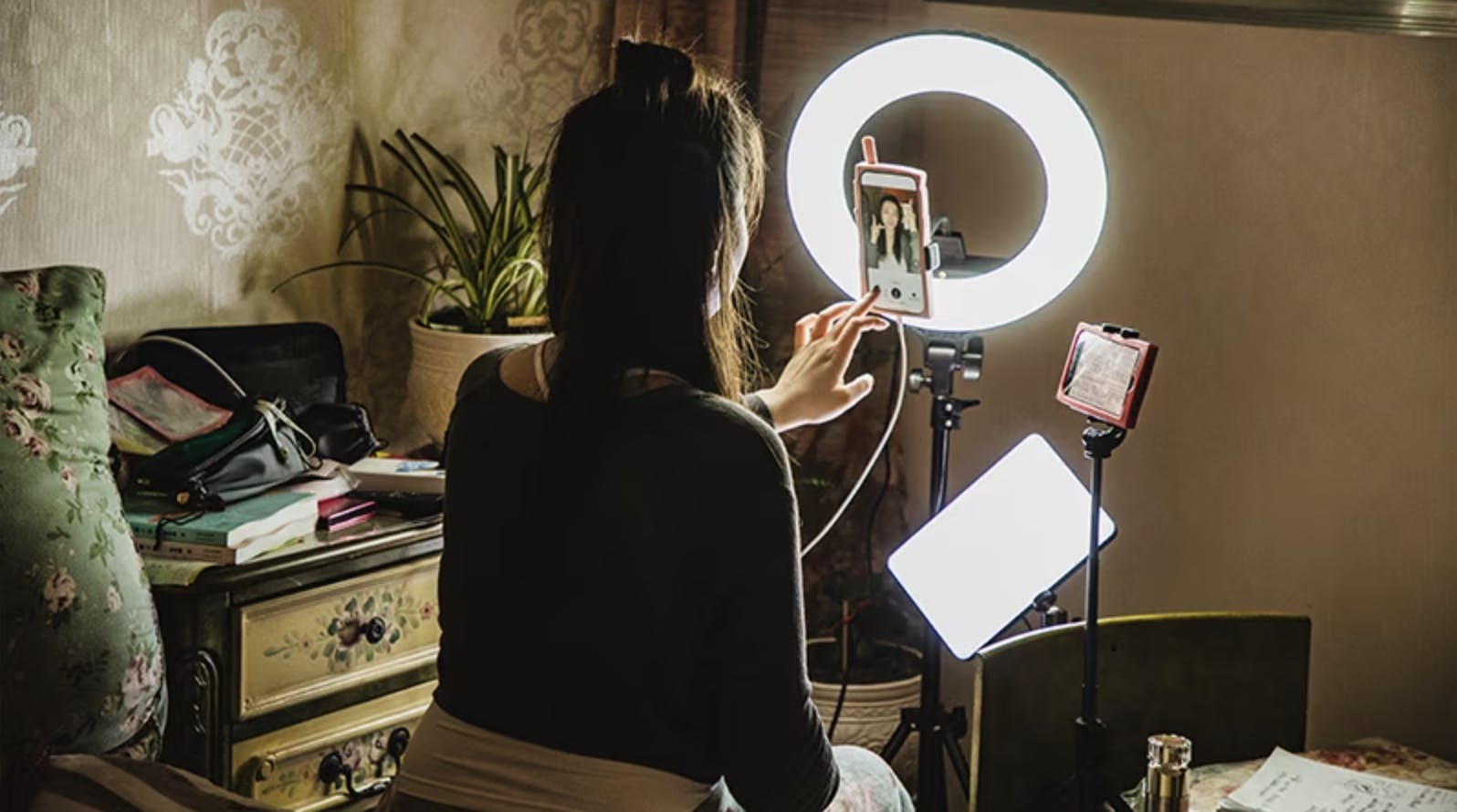 Image of a woman filming content for social media with a ring light