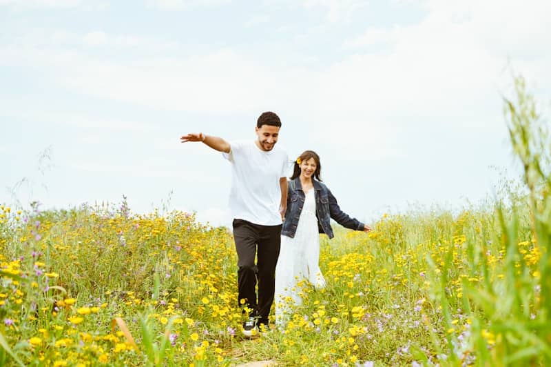 A couple enjoys a walk in a field.