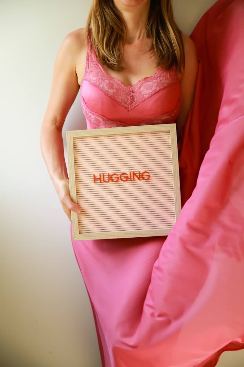 Woman holds a sign that says "hugging".