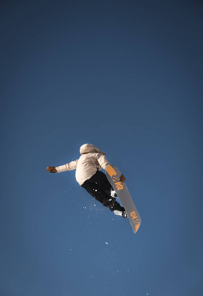 Snowboarder catches air against a clear blue sky