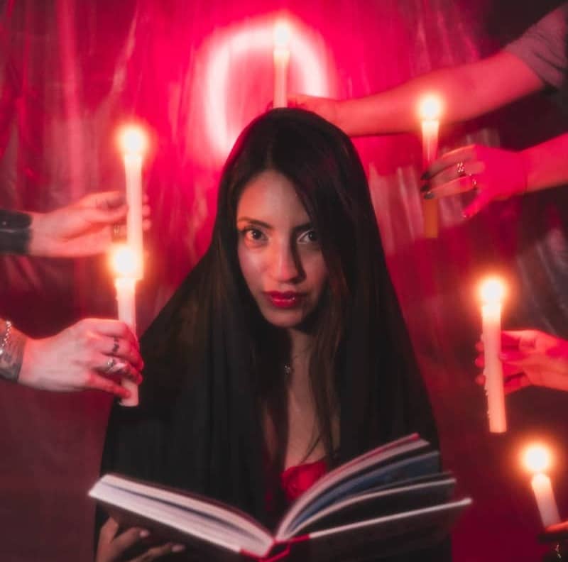 A woman reading a book with candles in the background
