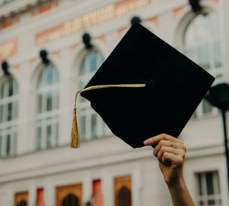 person holding black academic hat