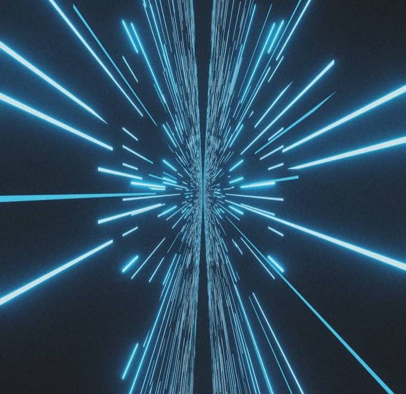 Blue light streaks converge in a dark space.