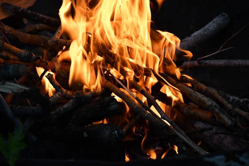Bright flames blaze over burning wood.