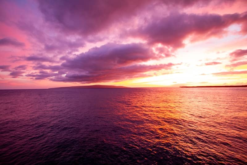 Sunset over the ocean, with colorful sky.