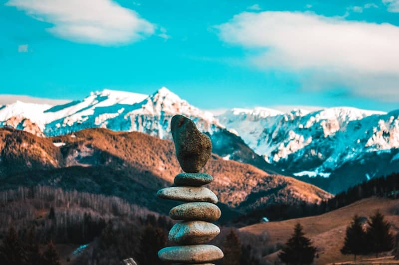 Stacked stones with snowy mountains in background