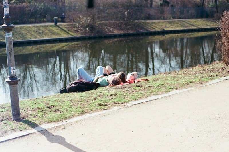 Two people relaxing by a calm canal