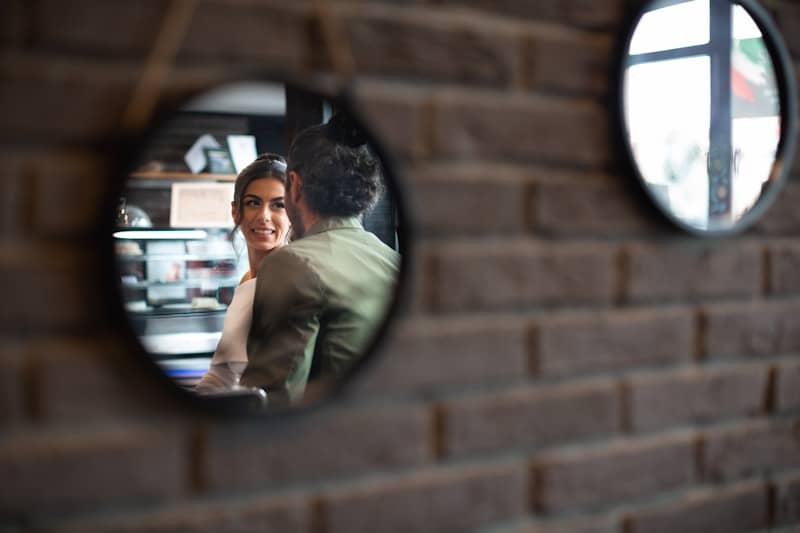 A couple gazes at each other in mirrors.