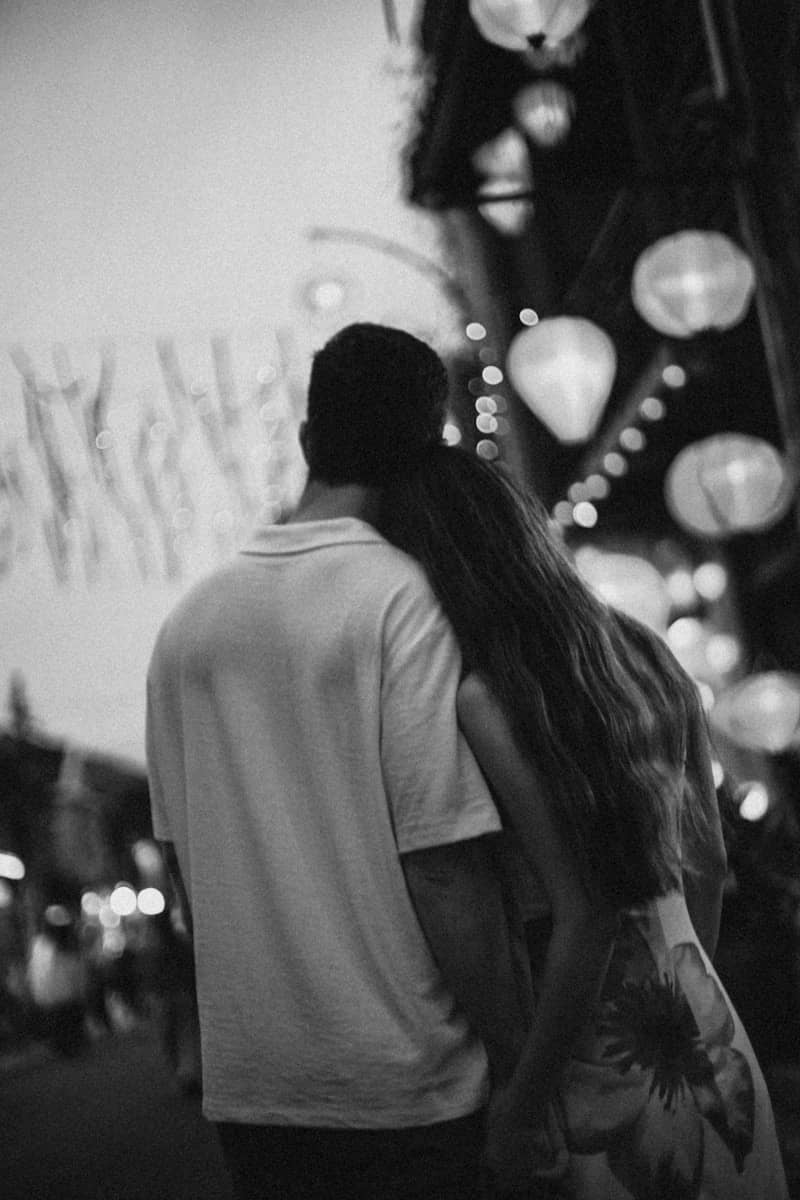 Couple embracing under glowing lanterns at night