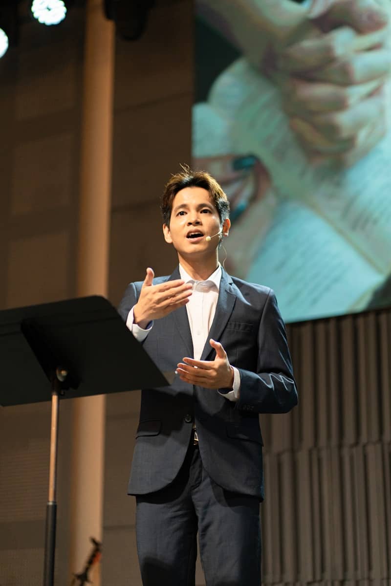 A man in a suit speaking at a podium.
