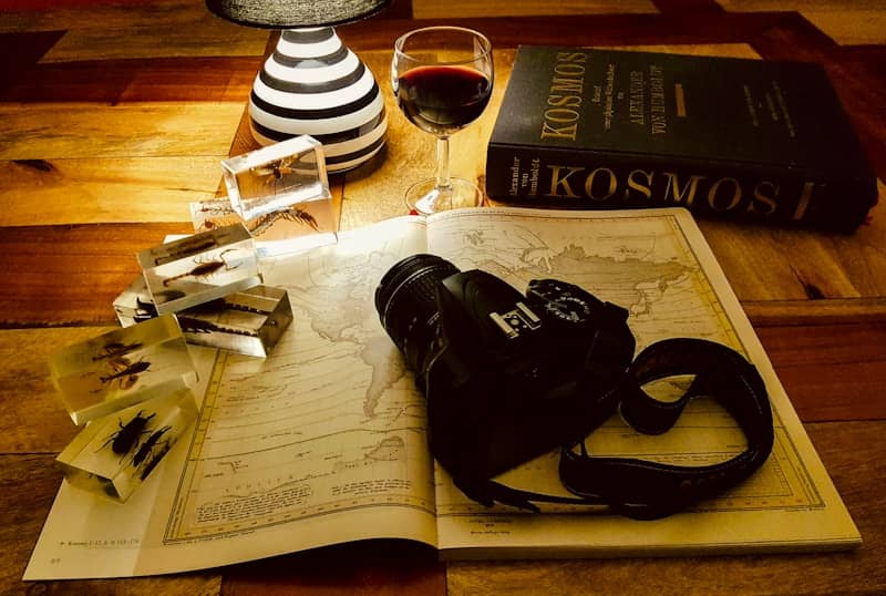 Travel planning with a camera, map, wine, and book.