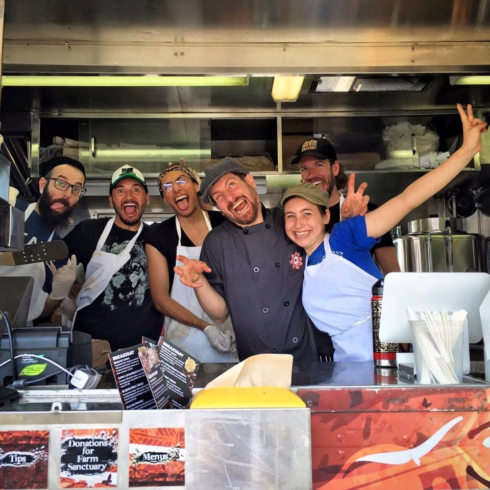The Cinnamon Snail crew crowded into the food truck window, laughing and pulling faces