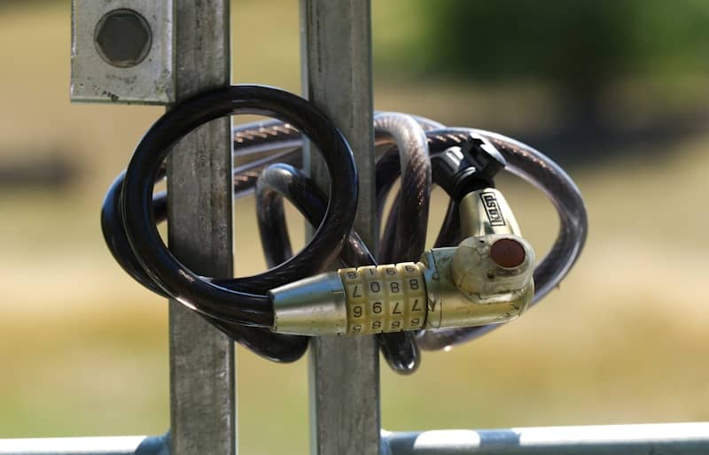 A black cable is wrapped around a metal pole.