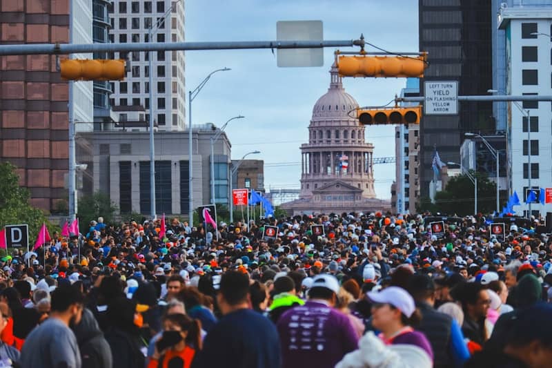 Large crowd gathers in front of a state capitol.