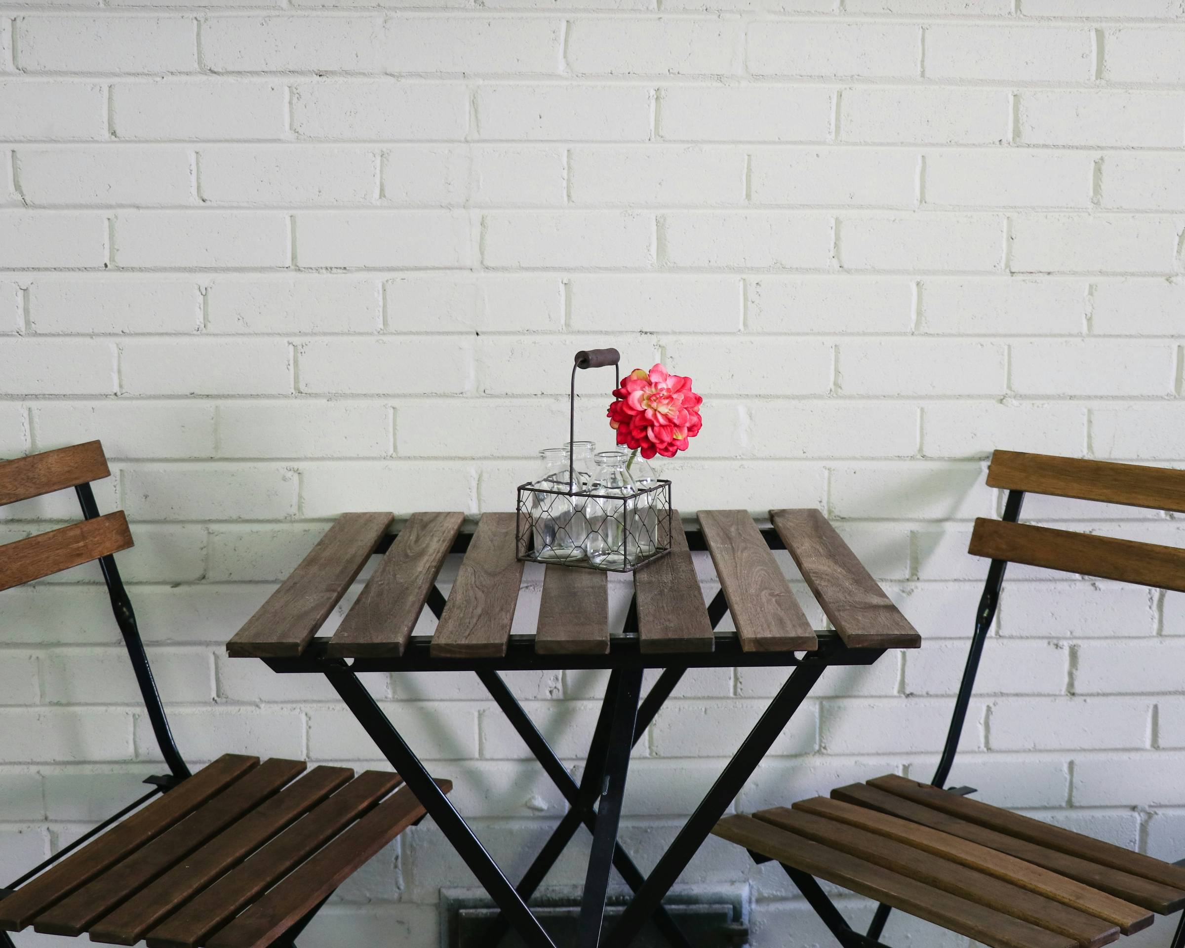 Bistro table and chairs with flower on table. Photo by Debbie Hudson.