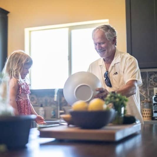 Grandfather and grandchildren prepare food in kitchen