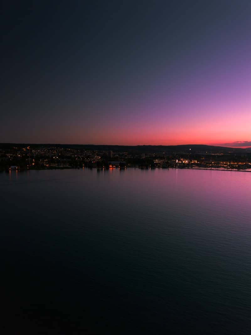 A large body of water sitting under a purple sky
