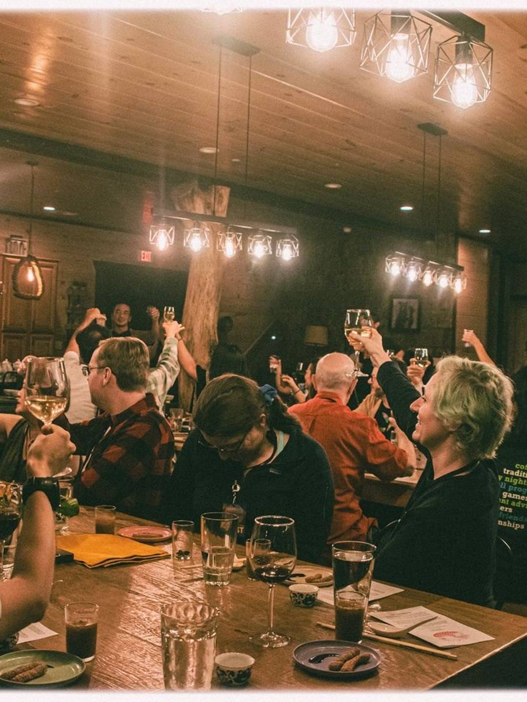 photo of attendees of the Multitudes retreat raising their glasses in a toast