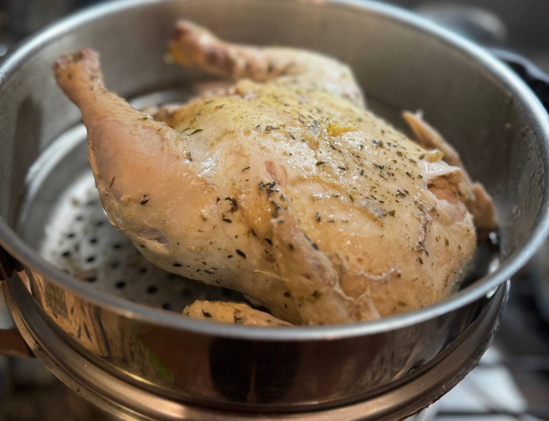 photo de poulet entier en cours de cuisson à la vapeur