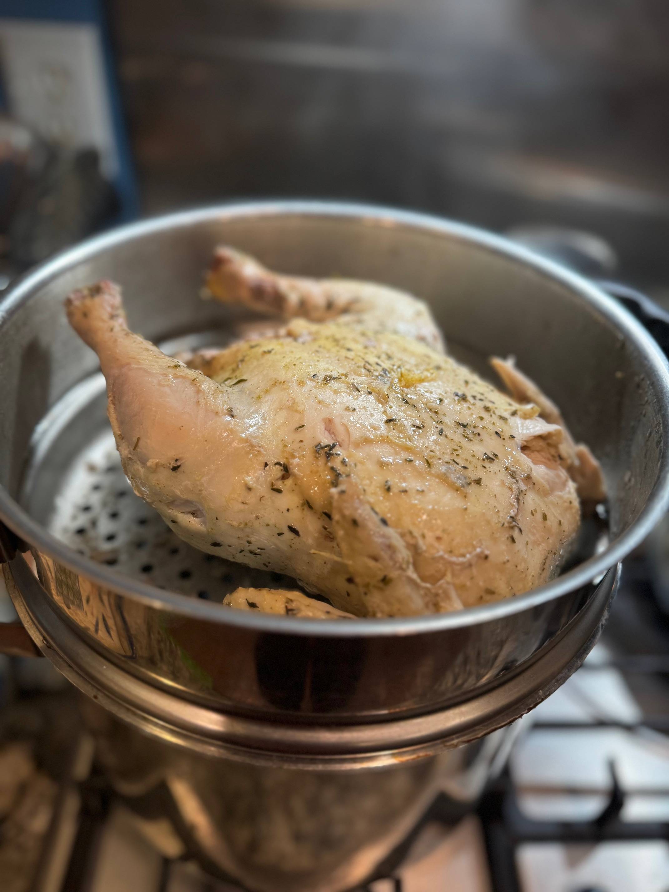 Close up picture of whole chicken in food steamer